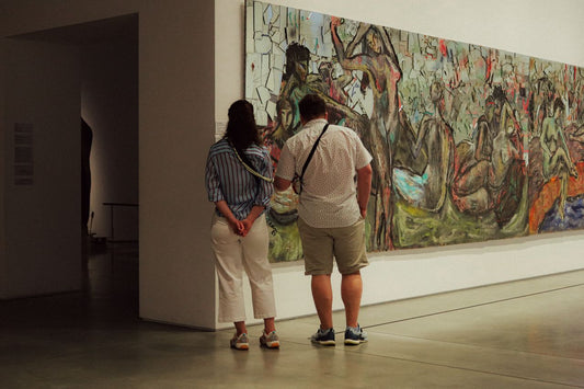 A wide horizontal view of art enthusiasts engaging with a large-scale abstract work in an editorial gallery setting; image found on Mitsooz to illustrate the language of presence and the studio voice.