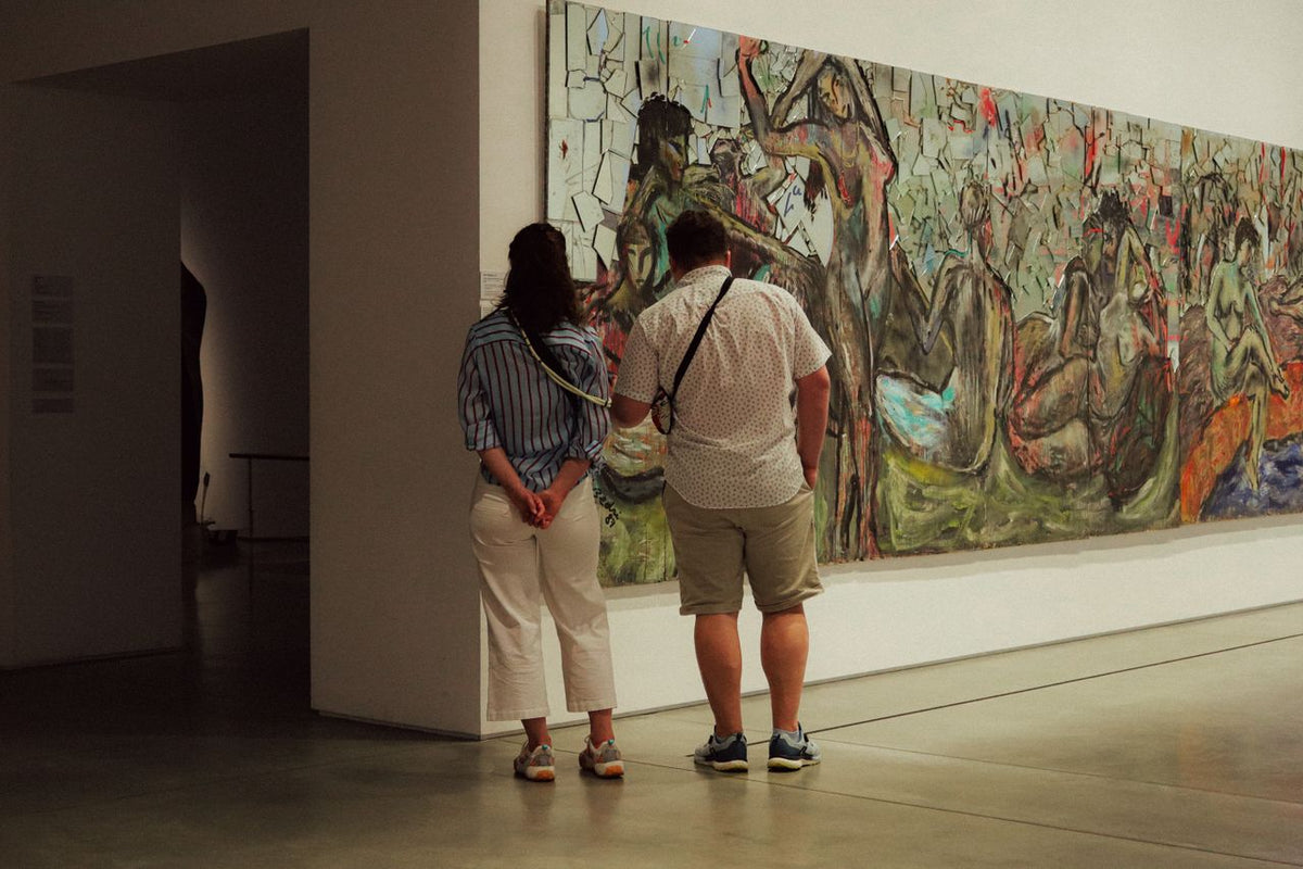A wide horizontal view of art enthusiasts engaging with a large-scale abstract work; image found on Mitsooz to illustrate the language of presence and the studio voice.
