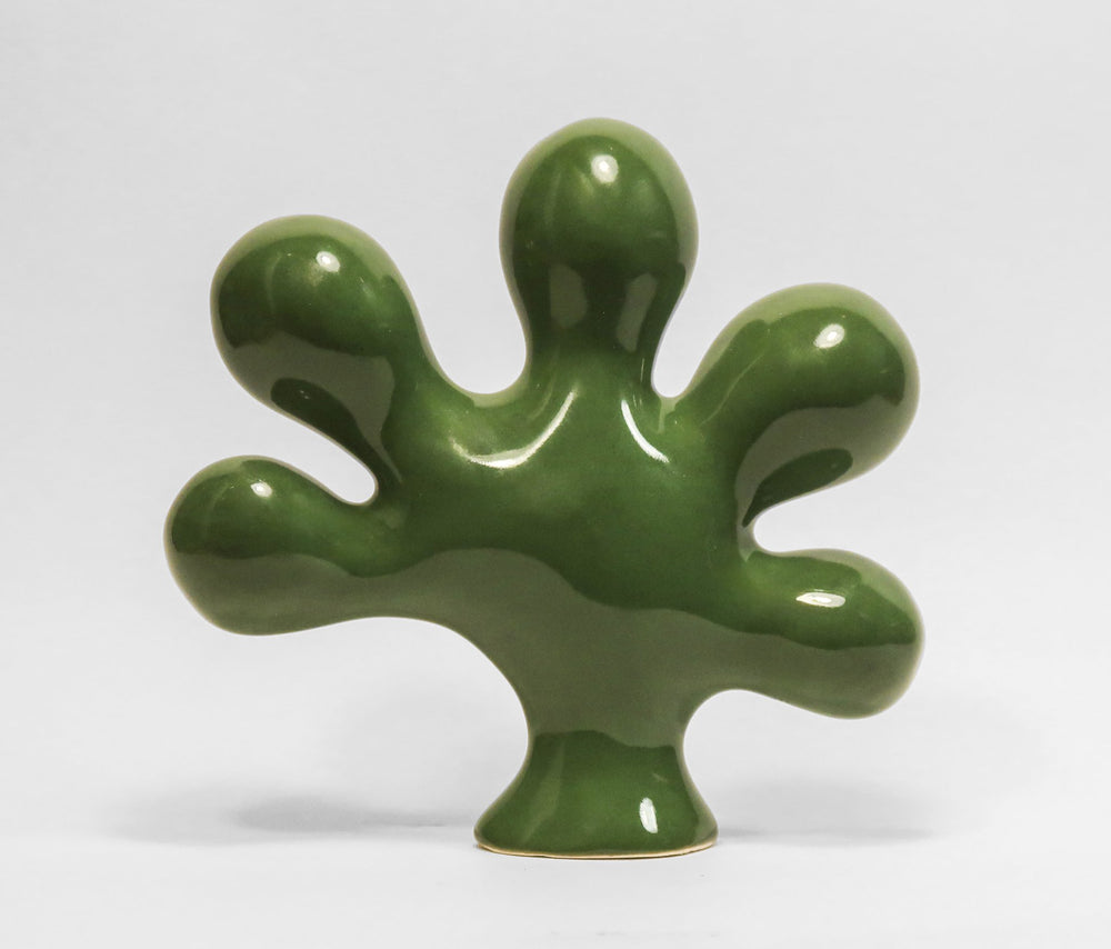 A vertical glossy green porcelain sculpture titled Sugar Maple Leaf by Andree Brown featuring hand-formed organic curves inspired by NYC Parks on Mitsooz.