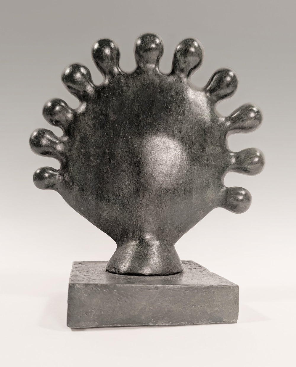 A contemporary organic bronze sculpture titled Sunflower by Andree Brown featuring a hand-formed circular floral shape with a dark gray satin-matte patina on Mitsooz.