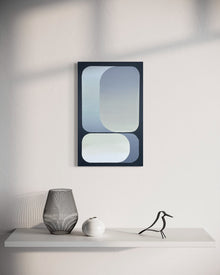 A 15x24 vertical original abstract painting titled Rising by Kevin Cross, featuring overlapping blue and slate grey gradients on foam-backed canvas. The artwork is displayed in a minimalist interior above a white shelf styled with a black wire vase, a white ceramic orb, and a modern black bird figurine on Mitsooz.