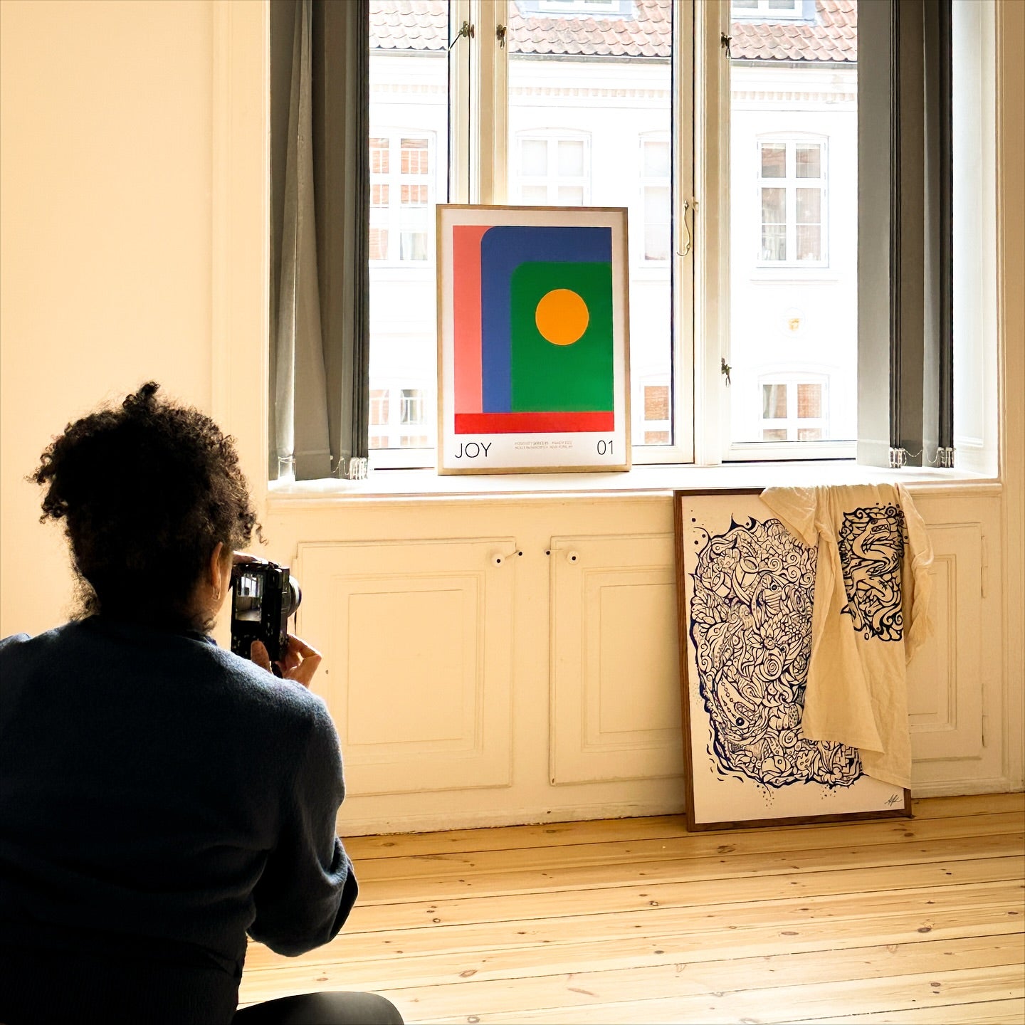 In her Copenhagen studio, mitsooz artist Holly McWhorter photographs her abstract work "Joy 01." The image captures her interdisciplinary process, treating the canvas as a structural space to explore how color and form interact to evoke deep emotion.
