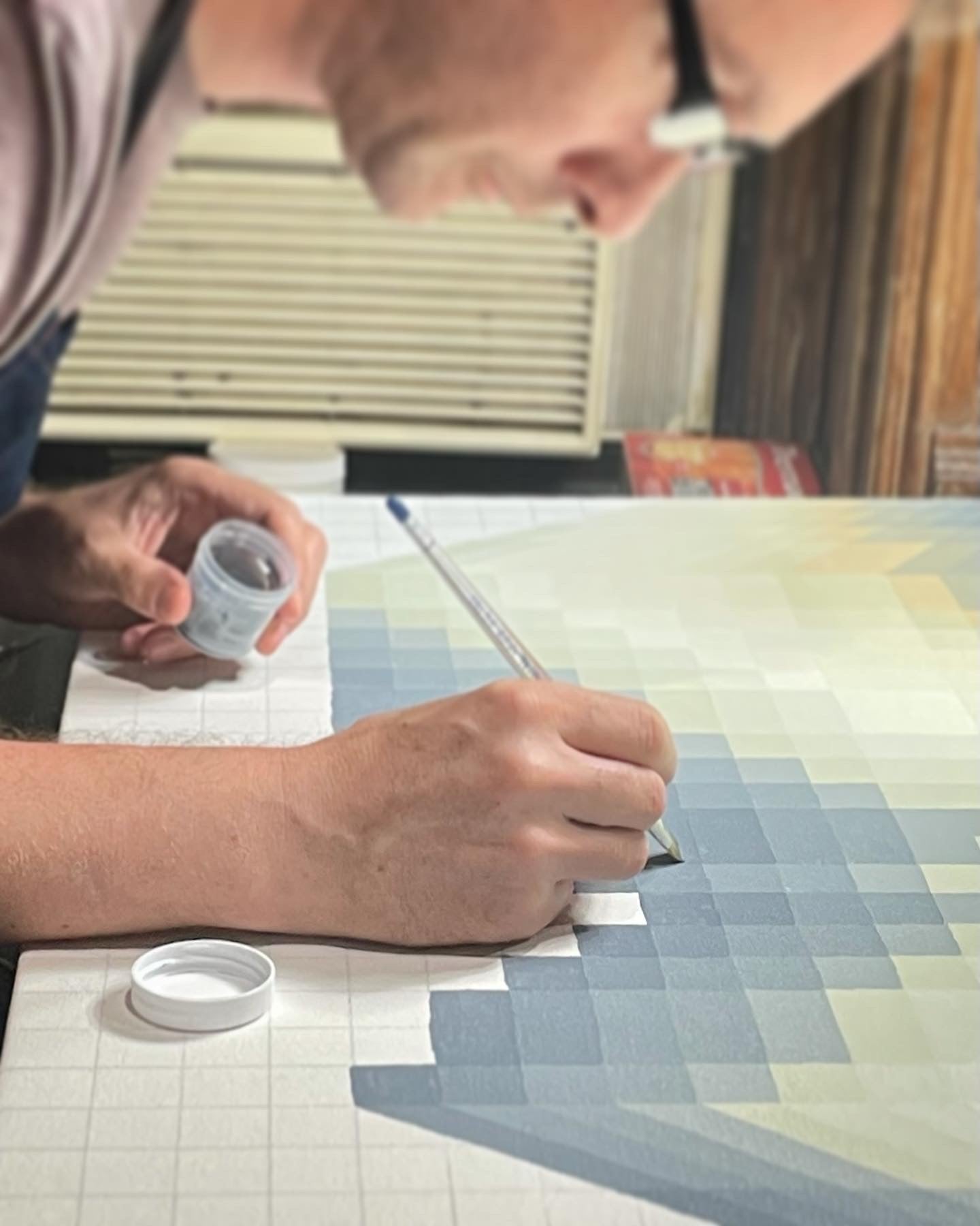 A close-up of Kevin Cross’s hand during his creative practice. Capturing the meditative rhythm and technical discipline required to establish atmospheric depth.
