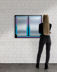 A vertical 30x36 original atmospheric abstract painting titled The View 5 by Kevin Cross, featuring a vibrant cyan and violet gradient with electric neon stripes at the base. The Work is displayed on a textured white brick wall in a minimalist gallery setting being viewed by a collector from behind at Mitsooz.