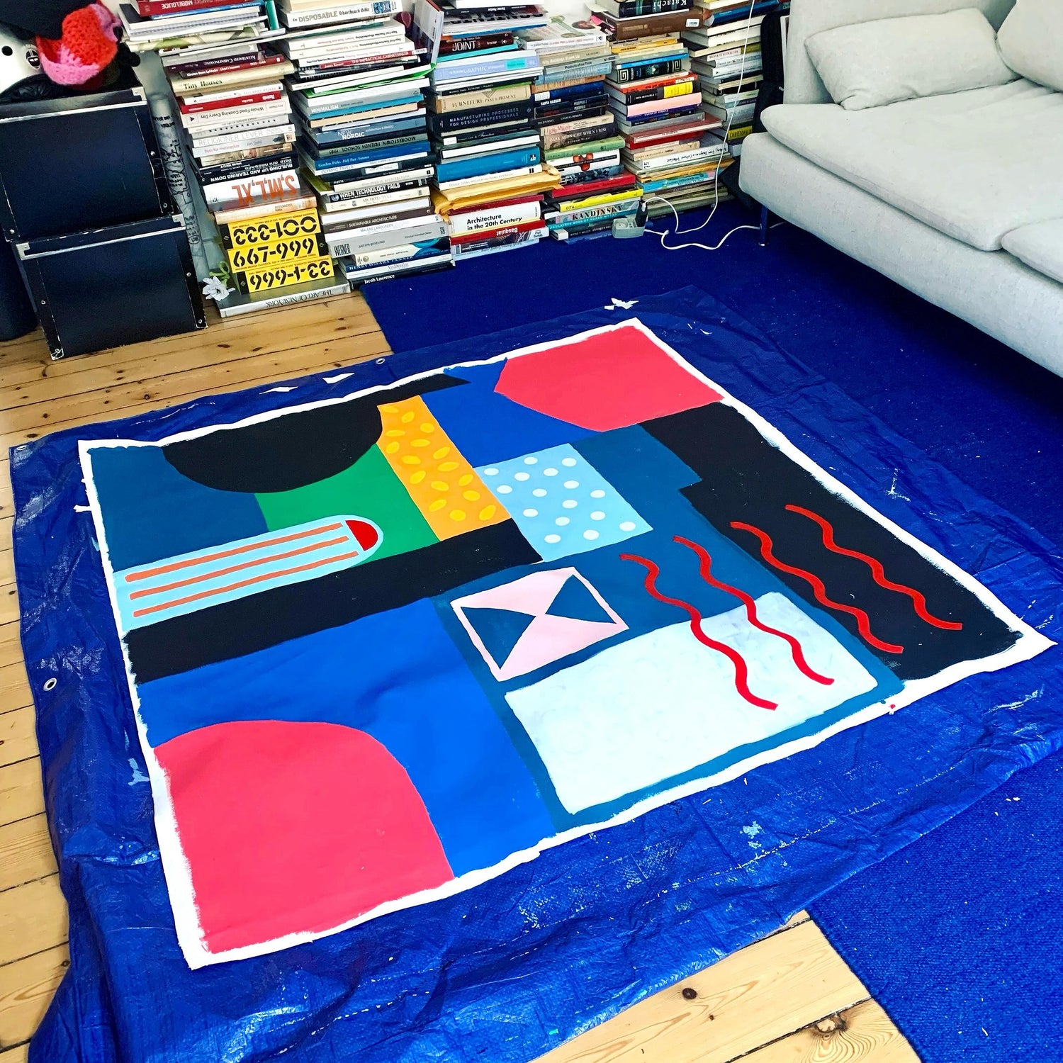 A 48x48 acrylic on canvas abstract painting by mitsooz artist Holly McWhorter, shown as a work in progress on her living room floor in Copenhagen. This piece represents a new style direction for the artist, using bold color blocks and patterns to explore the emotional weight of color and architectural clarity.