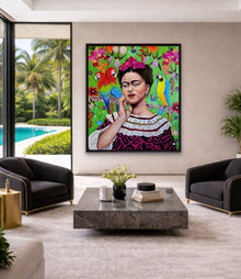 A monumental 40x60 original oil painting titled Frida Kahlo by Nersel Muehlen displayed in a high-end luxury living room. The photorealistic portrait of the iconic artist in a vibrant Mexican dress and floral tapestry hangs on a neutral wall between two black designer armchairs. The sophisticated setting features a marble coffee table and overlooks a tropical pool area with palm trees on Mitsooz.