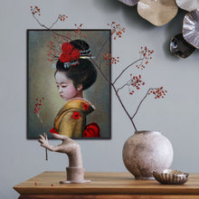 A framed 9x12 original oil painting titled Japanese Child by Nersel Muehlen hanging in a curated lifestyle setting on a grey wall. The decor includes a wooden console with a stone sculptural hand holding red winter berries and a textured round ceramic vase on Mitsooz.