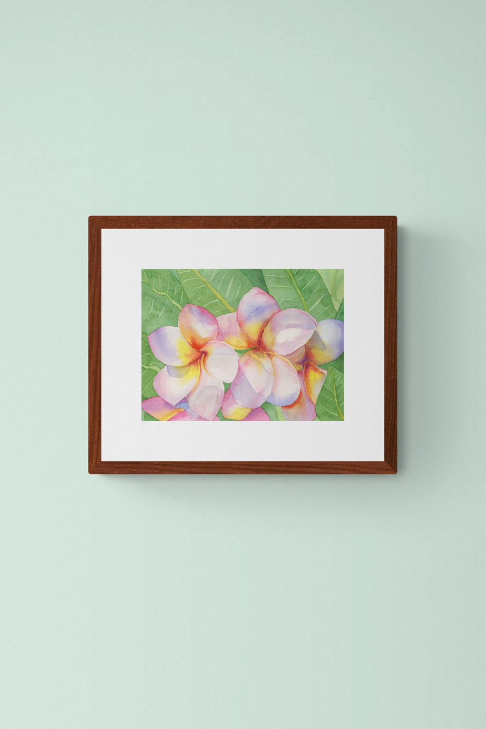 A horizontal 11x14 original botanical watercolor painting titled The Pink Plumeria Blooms by Ruth Wall, featuring vibrant pink and yellow tropical flowers with lush green leaves in a mahogany frame on Mitsooz.