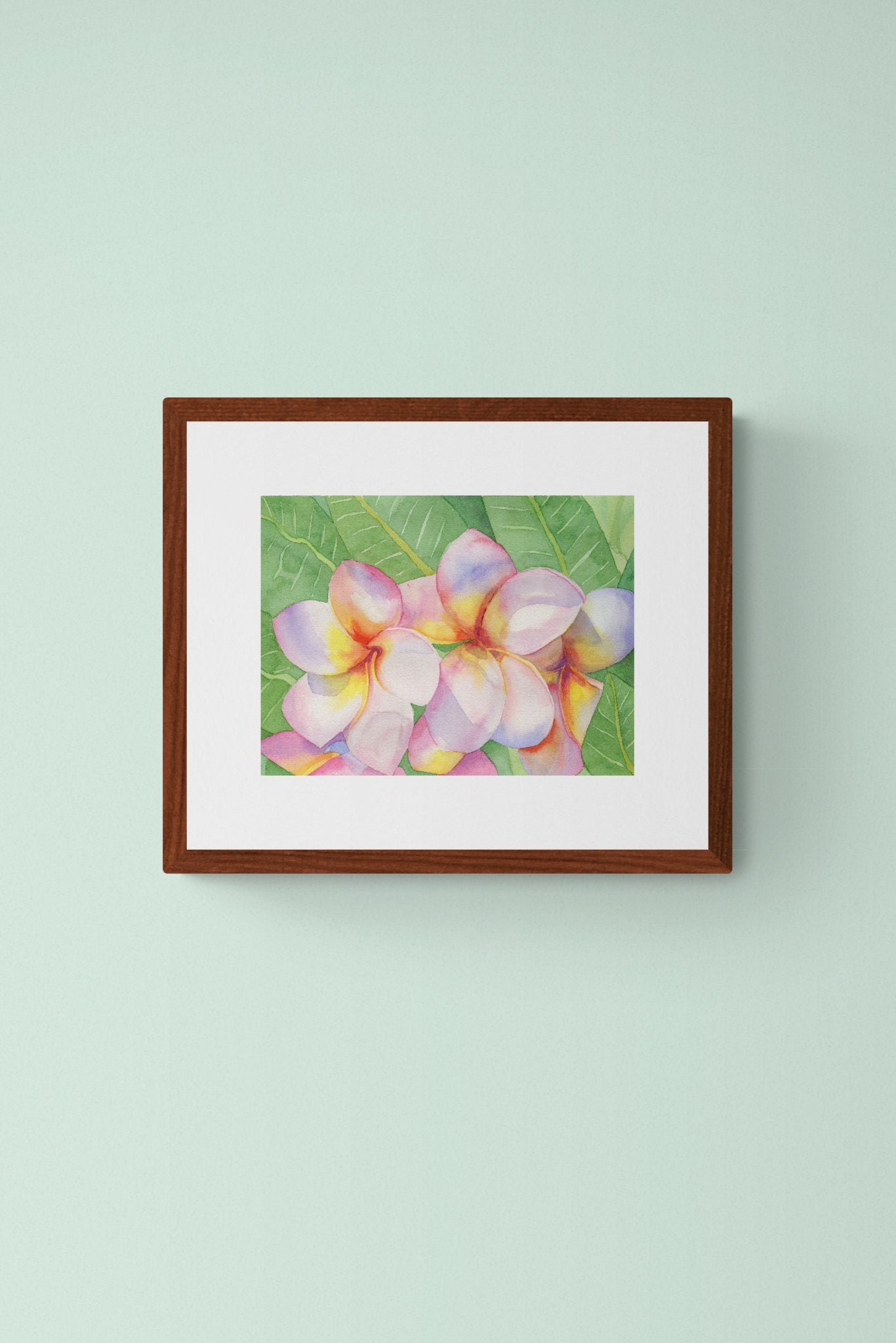 A horizontal 11x14 original botanical watercolor painting titled The Pink Plumeria Blooms by Ruth Wall, featuring vibrant pink and yellow tropical flowers with lush green leaves in a mahogany frame on Mitsooz.